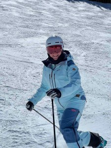 Suzanne smiling for the camera while telemark skiing.